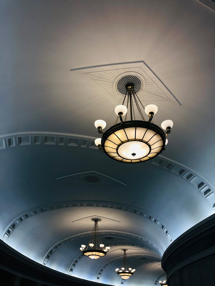 Sophisticated chandelier lighting in a classic architectural interior with vaulted ceilings.